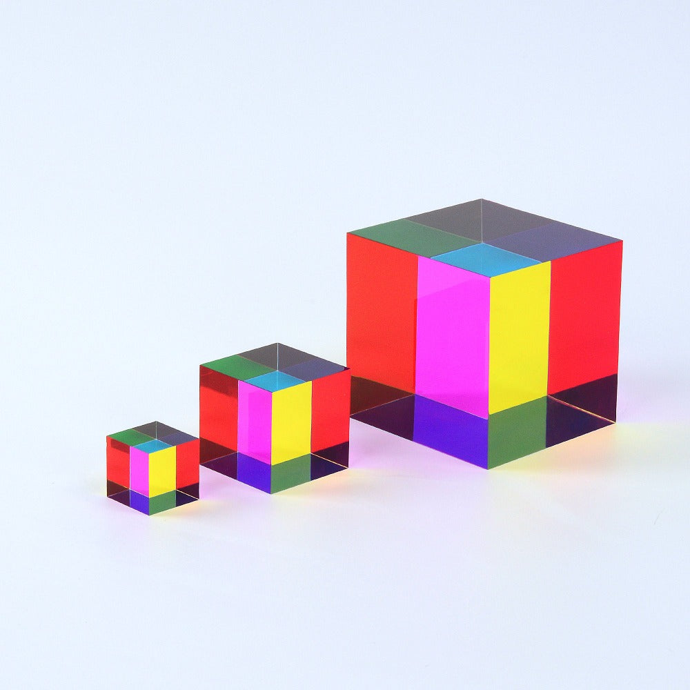 A translucent CMY Cube reflecting and transmitting light on a bright surface